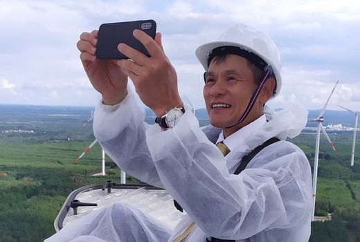 Mann mit Smartphone auf Windrad im Windpark Klettwitz